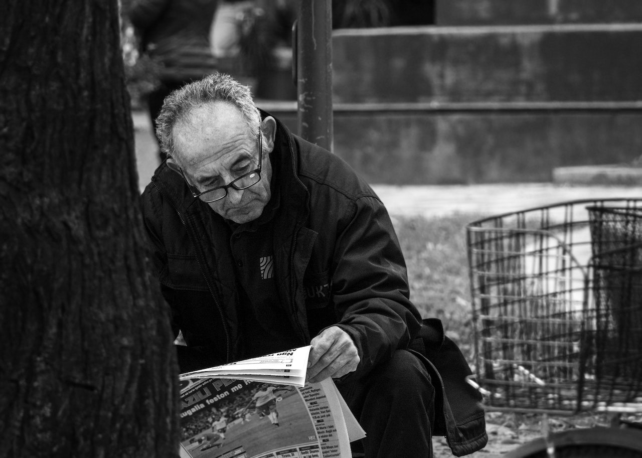 An Elderly Man Reading a Newspaper | Veteran Car Donations
