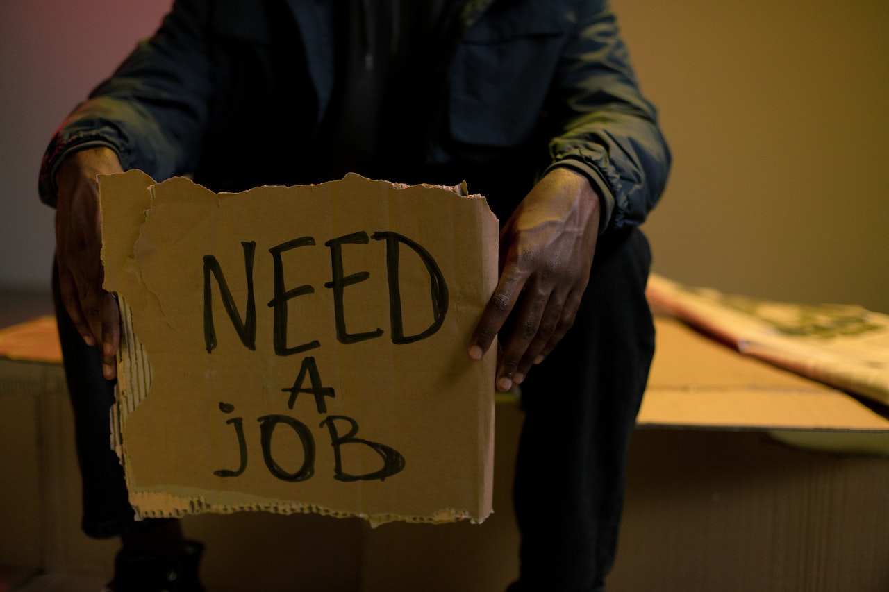 Homeless man holding cardboard in hands | Veteran Car Donations