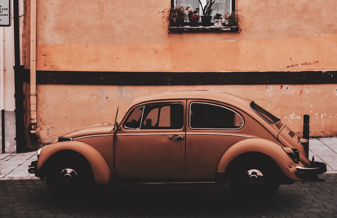 Beige Volkswagen Beetle Coupe Parked Near Concrete Building | Veteran Car Donations
