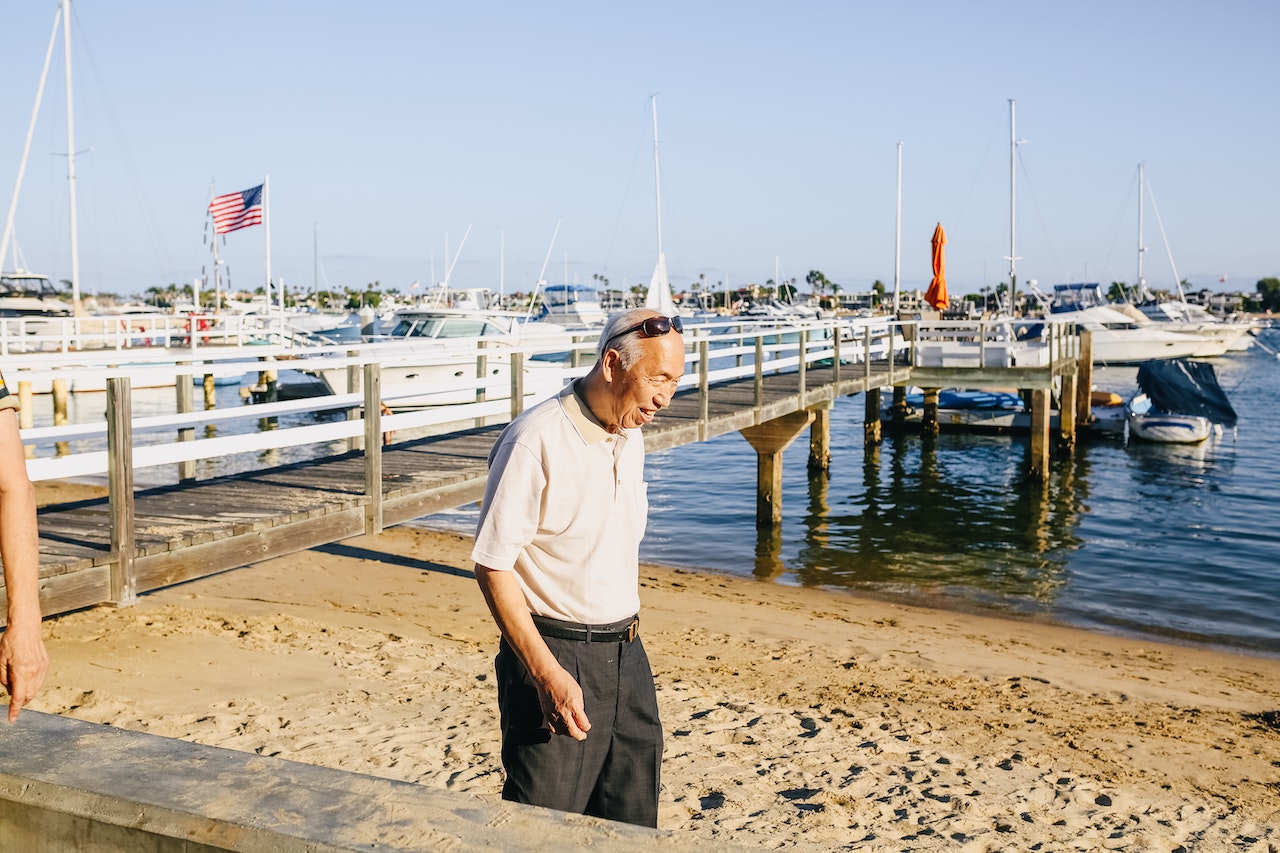 Man in White Crew Neck T-shirt and Black Pants Standing on Beach | Veteran Car Donations
